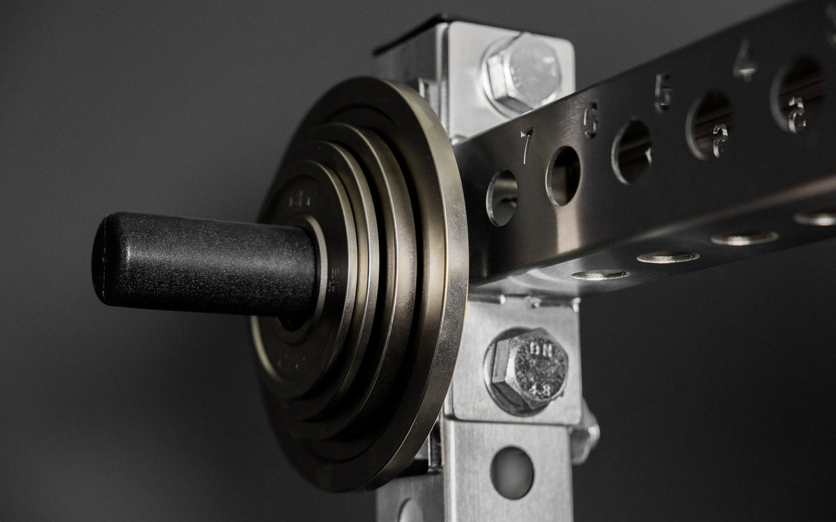 Rep Fitness Calibrated Steel Plates (KG) loaded on a weight horn, highlighting a calibrated tolerance